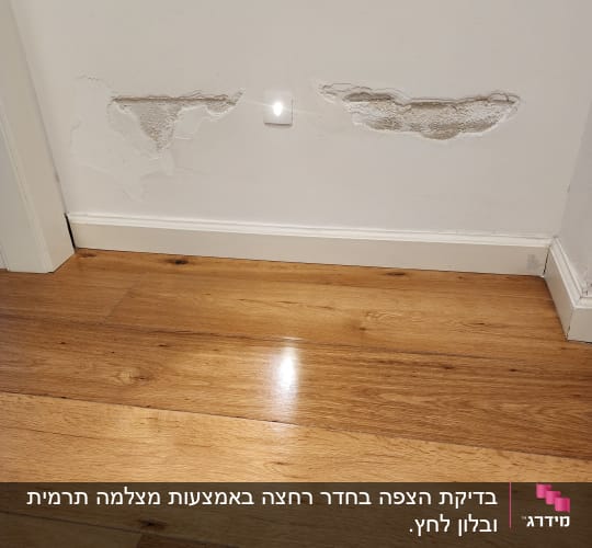 קיר עם קילופי טיח מעל רצפת עץ